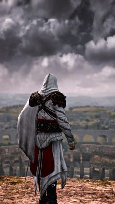 a man dressed in medieval clothing walking towards the camera on a cloudy day with dark clouds overhead