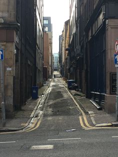 an empty city street with no cars on the road and buildings lining both sides,