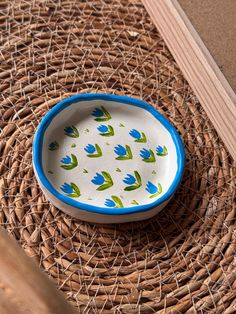 a blue and white bowl sitting on top of a wicker table