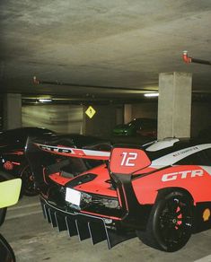 several race cars parked in a parking garage