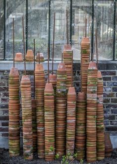 stacks of clay pots sitting in front of a window