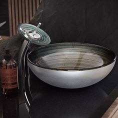 a bowl that is sitting on top of a counter next to a bottle and soap dispenser