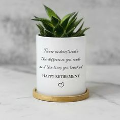 a plant in a white ceramic pot with a gold rim reads never underestrante the defense you made and the love you looked happy retirement