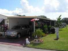 a car parked in front of a mobile home with an umbrella over it's head