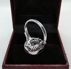 a silver ring sitting inside of a wooden box