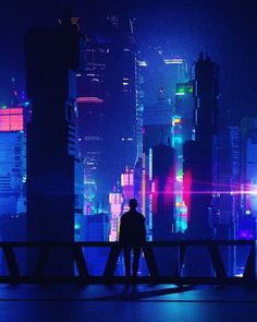 two people standing on a bridge in front of a cityscape with brightly colored lights