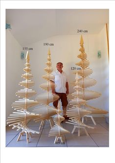 a man standing in front of a wooden christmas tree made out of strips of wood