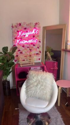 a white chair sitting on top of a hard wood floor next to a pink wall