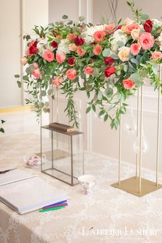 an arrangement of flowers and greenery on a table