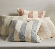 three striped pillows on a white couch