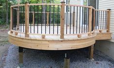 a wooden deck with metal railings next to a house