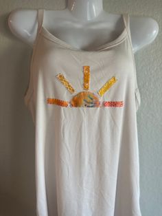 a white tank top with the sun painted on it