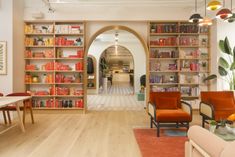 a living room filled with lots of furniture and bookshelves next to a doorway