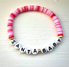 Heishi beaded bracelet that is ~7 inches long (average women's size bracelet). Bead colors: variations of pink and red, gold. Letter beads are black and white. Orchard Park Ny, Clay Bead Necklace, Hippie Bracelets, Bracelet Bead, Clay Bead, Gold Letter, Christmas Bracelet