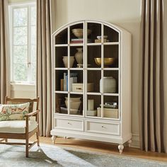 a white bookcase with glass doors in a living room