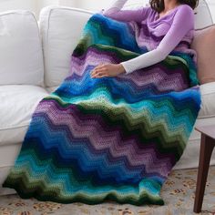 a woman sitting on a couch holding a blanket