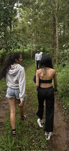 two women walking down a path in the woods