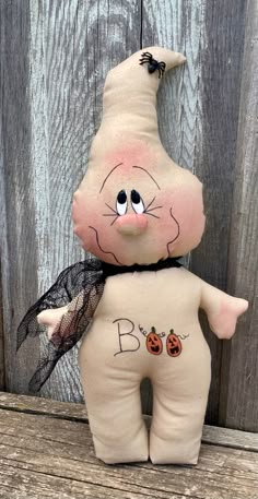 a stuffed animal that has been placed on a wooden surface with the word boo written on it