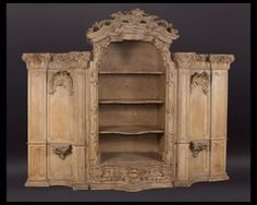 an old wooden cabinet with carvings on the doors and shelves in it's center