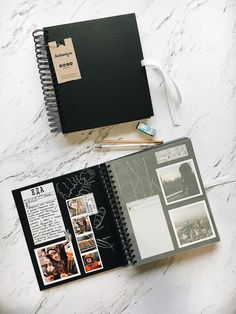 an open notebook with pictures and writing on it next to a pen, pencils and paper