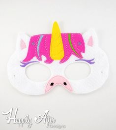 a white mask with pink, yellow and purple unicorns on it's face