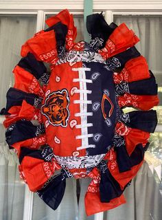 an orange and black football wreath hanging from a window