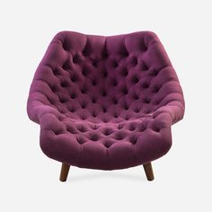 an upholstered purple chair with wooden legs