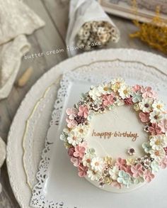 a birthday cake decorated with flowers on a plate