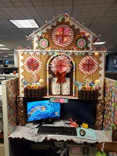 an office cubicle decorated with gingerbread house and candy land decorations on the desk