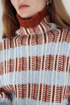 a woman with long hair wearing a turtle neck sweater