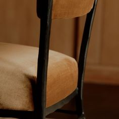 a close up of a chair with a tan seat cover on it's back