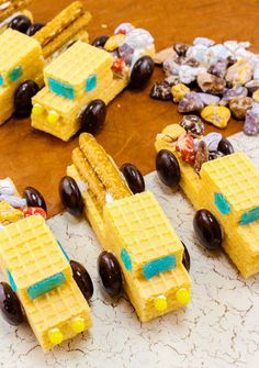 some yellow cars made out of waffles sitting on a table next to chocolate chips