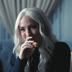 a woman with long white hair eating food