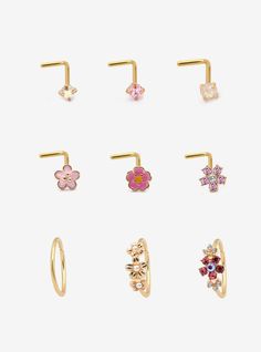 six pairs of gold nose rings with flowers on each one and an ear pin in the middle