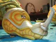 a close up of a snail statue on a blue table cloth with other items in the background