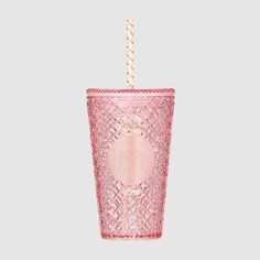 a pink glass cup with a straw sticking out of it