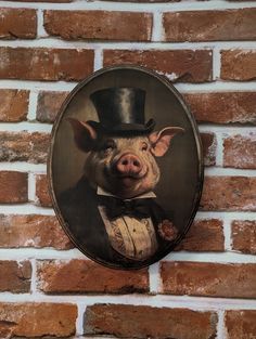 a pig with a top hat and bow tie hanging on a brick wall next to a brick wall