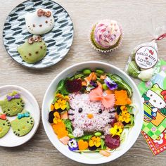 hello kitty cupcakes and other treats are on the table next to a bowl of food