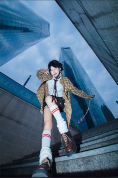 a woman in short shorts and boots standing on some steps with her hands behind her head