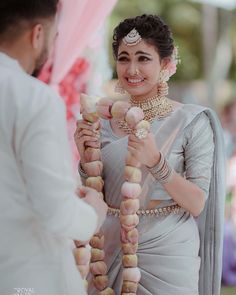 a man and woman standing next to each other in front of a wedding arch with food on it