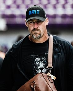 a man wearing a hat and carrying a brown bag