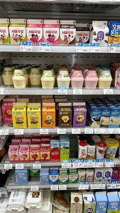 dairy products are displayed on shelves in a grocery store's display case, including milk and yogurt