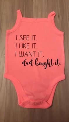 a pink onesuit with the words i see it, i like it, i want it