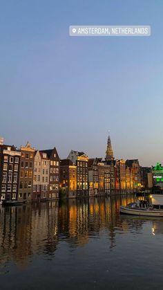 the water is calm and there are many buildings on the shore in the city at night