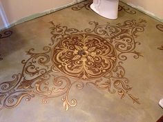 a bathroom with an intricately painted floor and toilet in the corner next to it