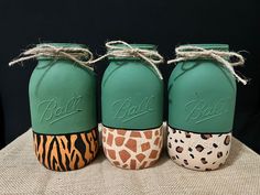 three green mason jars decorated with giraffe prints and the word ball on them