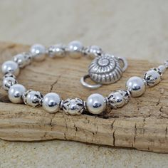 Elevate your boho chic style with this lovely beachy accessory featuring a stunning Thai conch shell closure. This handcrafted beaded bracelet combines the beauty of bohemian design with coastal style. Alternating sterling silver round beads are capped with Bali sterling silver and finished with an S-style Thai clasp. Orders ship Monday - Friday via US First Class mail. Processing time is 1 - 2 days; most items ship the same day. Thank you for choosing BeadedMoonJewery for your jewelry needs. If you hav questions or customization requests, please feel free to message me. I take pride in providing high-quality, unique pieces that you'll cherish for years to come. Bohemian Beaded Oyster Bracelets For Beach, Bohemian Oyster Beaded Bracelets For Beach, Bohemian Pearl Bracelet For Summer, Summer Bohemian Pearl Bracelet, Bohemian Pearl Bracelet For Beach With Round Beads, Bohemian Pearl Bracelet With Round Beads For Beach, Bohemian Silver Beaded Bracelets With Large Beads, Bohemian Silver Beaded Bracelets For Beach, Bohemian Silver Beads Jewelry For Beach