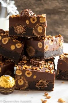 a pile of chocolate brownies with nuts on top