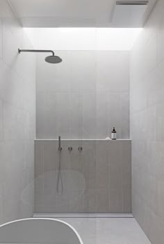 a bathroom with a walk in shower next to a white bathtub and tiled walls