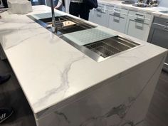 a person standing in a kitchen next to a sink and counter top with an oven